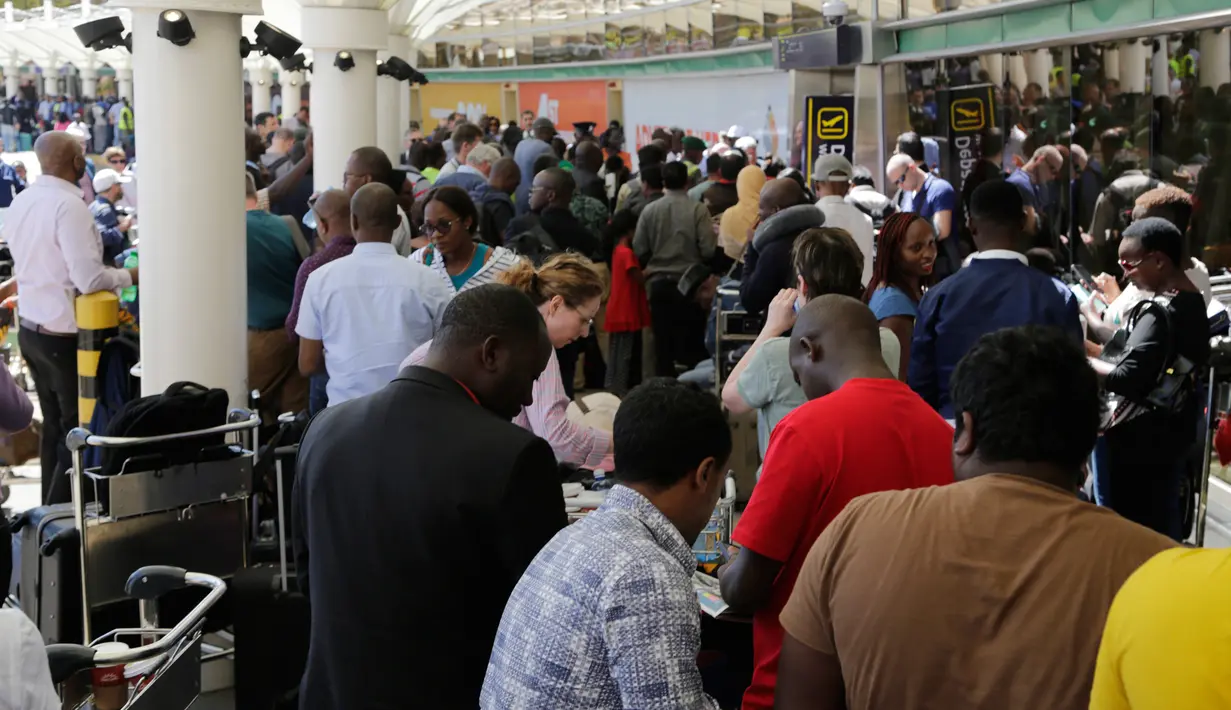 Penumpang yang terdampar setelah penundaan penerbangan karena aksi mogok pekerja maskapai keluar dari bandara JKIA di Nairobi, Rabu (6/3). Para penumpang yang sudah menunggu lama hingga berjam-jam, diminta meninggalkan bandara. (AP Photo/Khalil Senosi)