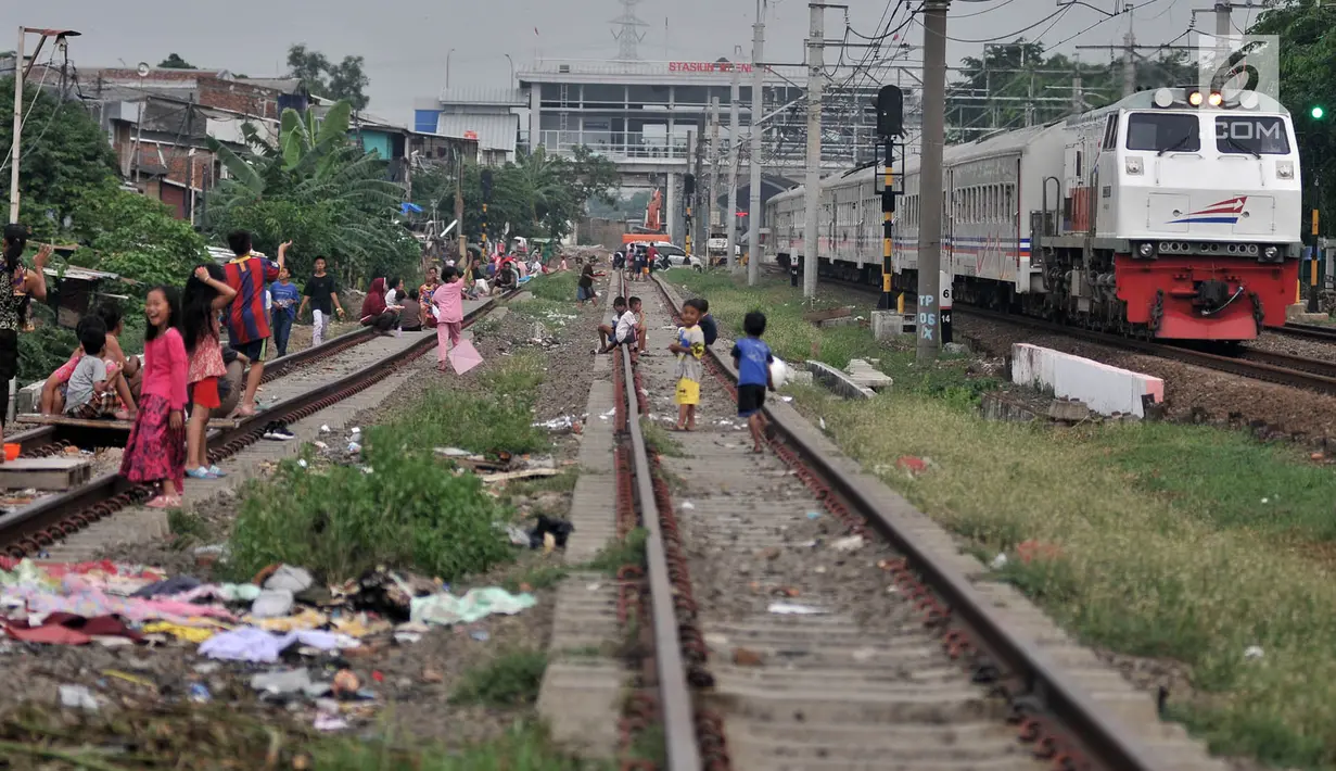 Anak-anak bermain layang-layang di rel kereta api kawasan Jakarta Timur, Kamis (3/1). Rel yang sering dilintasi kereta api tersebut sangat membahayakan diri mereka. (Merdeka.com/Iqbal Nugroho)