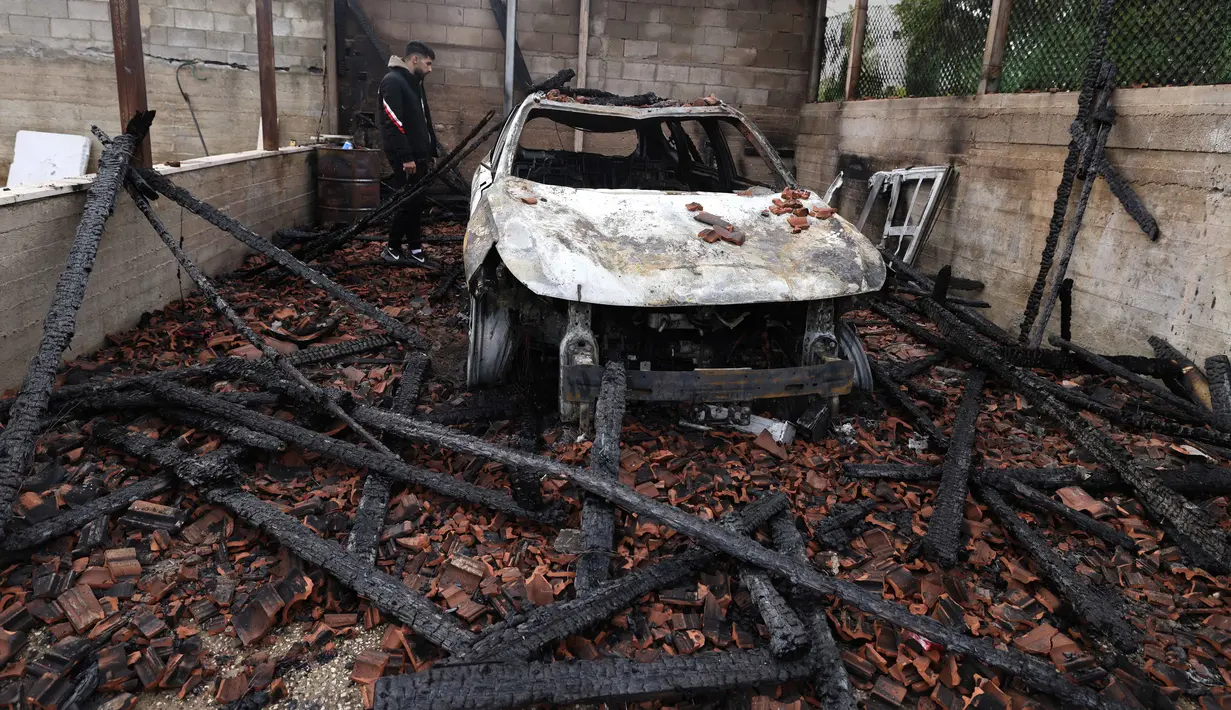 Kementerian Luar Negeri Palestina mengecam keras serangan ini sebagai eskalasi serius yang menargetkan warga sipil, rumah, dan properti selama suasana hari raya. Tampak dalam foto, seorang pria Palestina memeriksa kendaraan yang hangus terbakar setelah serangan yang dilaporkan dilakukan oleh pemukim Israel di desa Deir al-Hatab, sebelah timur kota Nablus, di Tepi Barat, wilayah yang diduduki Israel pada Senin 23 Maret 2026. (JAAFAR ASHTIYEH/AFP)