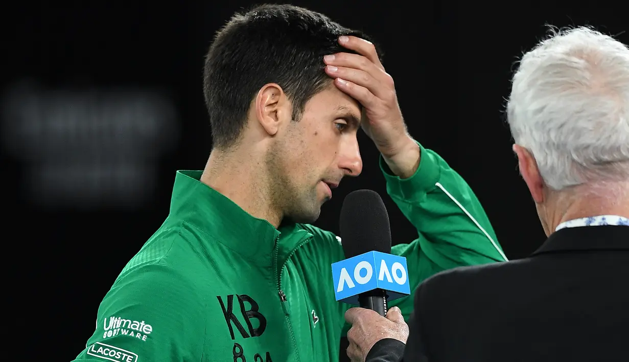 Petenis Serbia, Novak Djokovic, menangis saat diwawancara tentang Kobe Bryant seusai laga Australia Open 2020 di Melbourne, Selasa (28/1). Beri penghormatan dirinya memakai jaket inisial Kobe Bryant. (AFP/Greg Wood)