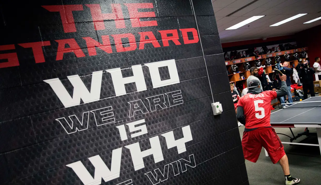 Pemain Atlanta Falcons, Matt Bosher beraksi bermain tenis meja di ruang ganti di Flowery Branch, Ga (26/1). Dengan bermain tenis meja para pemain american football ini dapat akrab dengan rekan-rekannya. (AP Photo/David Goldman)