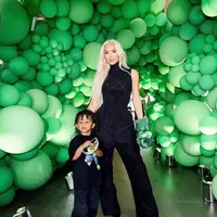 Di momen spesial ini, Kim Kardashian tampil kompak dengan Psalm West dalam balutan outfit serba hitam. Kim tampak mengenakan turtleneck sleeveless top yang dipadukan dengan long pants warna hitam. (Instagram/kimkardashian).