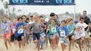 Sejumlah anak-anak berlari di atas pasir mengikuti 'Tot Trot' selama Nautica Malibu Triathlon di Pantai Zuma di Malibu, California (14/9). (Noel Vasquez / Getty Images untuk Nautica / AFP)