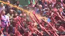 Umat Hindu India disemprot dengan cairan berwarna dalam festival keagamaan Holi di Kuil Swupramayan Kalupur, Ahmedabad, Rabu (20/3). Festival Holi atau yang dikenal dengan Festival Warna menjadi ajang untuk saling berbagi cinta. (SAM PANTHAKY / AFP)