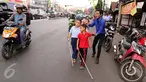 Guru membimbing siswa PSBN Cahaya Bathin penyandang tunanetra mengikuti praktik orientasi mobilitas di Cawang, Jakarta, Selasa (11/4). Praktik itu untuk melatih kemandirian siswa menghadapi situasi apapun dalam kesehariannya. (Liputan6.com/Gempur M Surya)