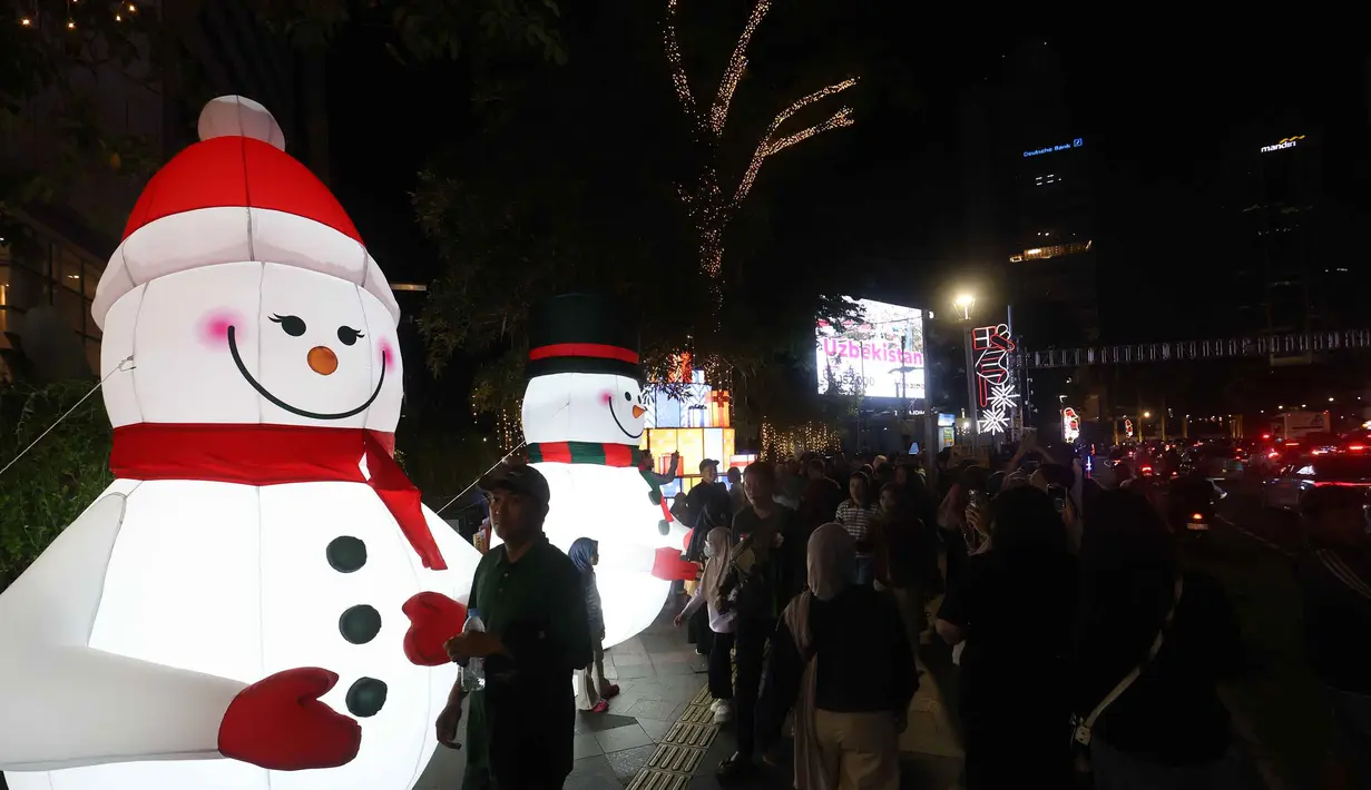 Sebagai informasi, Jakarta Light Festival 2025 memiliki daya tarik tersendiri, khususnya dalam pertunjukan video mapping yang dihadirkan sebagai rangkaian acara. Tampak dalam foto, warga menikmati suasana Jakarta Light Festival 2025 di sekitar Bundara Hotel Indonesia, Jakarta, Selasa (23/12/2025). (Kapanlagi.com/Budy Santoso)
