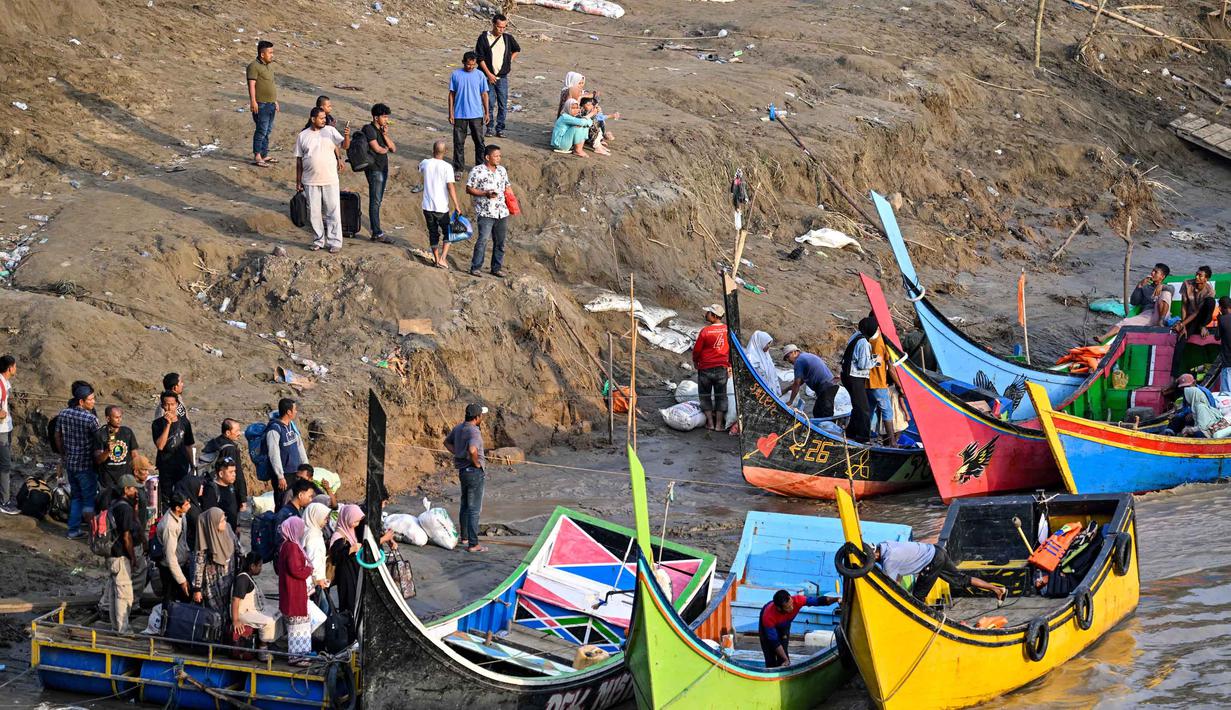 Warga pun harus rela antre untuk menyeberangi sungai Peusangan menggunakan jasa perahu nelayan. Tampak dalam foto, warga terdampak banjir menaiki perahu untuk menyeberangi Sungai Peusangan di Kuta Blang, Kabupaten Bireuen, Provinsi Aceh, Selasa 9 Desember 2025. (CHAIDEER MAHYUDDIN/AFP)