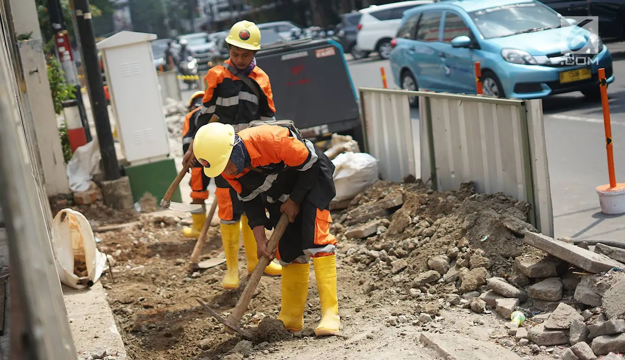 Aktivitas pekerja membongkar jalur pejalan kaki (trotoar) di Jalan Cikini Raya, Jakarta, Jumat (14/6/2019). Pemprov DKI bakal melakukan revitalisasi  trotoar di Jalan Cikini Raya dan Jalan Kramat Raya sepanjang 10 kilometer dengan anggaran sebesar Rp75 miliar. (Liputan6.com/Immanuel Antonius)