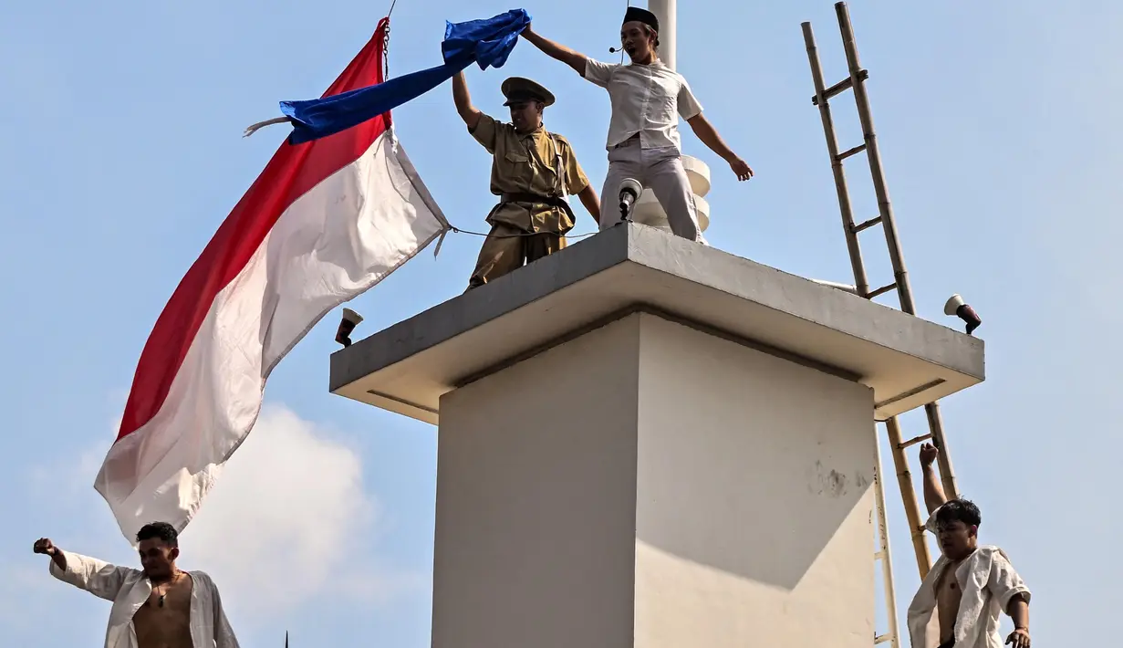 Beberapa pemuda Indonesia melakukan aksi heroik dengan menurunkan dan merobek bendera Belanda yang berwarna merah, putih, biru dan dengan sengaja menyisakan bagian merah dan putih saja. (JUNI KRISWANTO/AFP)