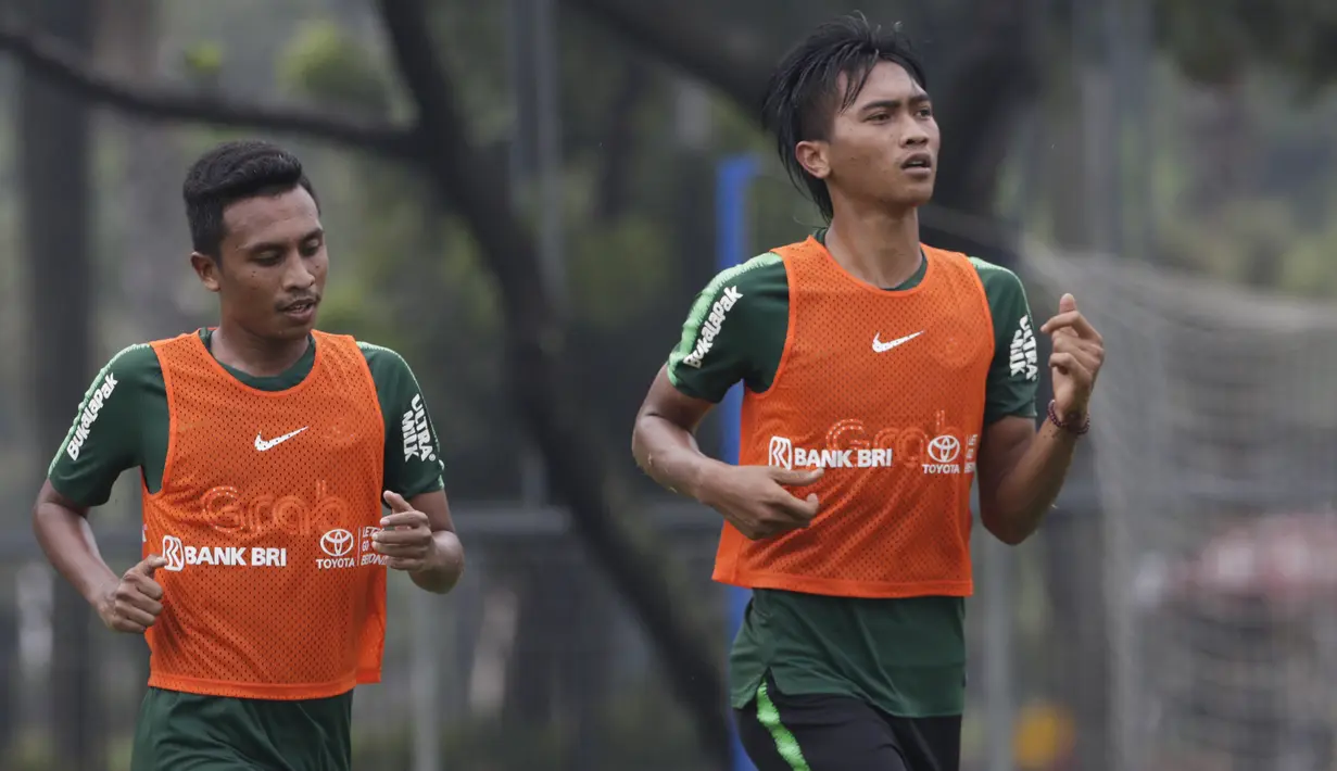Pemain Timnas Indonesia U-22, Jayus Hariono dan Syafril Lestaluhu, melakukan pemanasan saat latihan di Lapangan ABC, Jakarta, Senin (14/1). Latihan ini merupakan persiapan jelang Piala AFF U-22. (Bola.com/Vitalis Yogi Trisna)