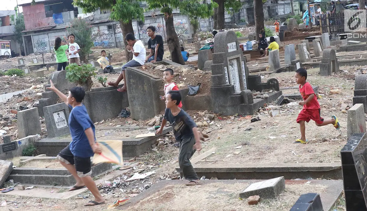 Anak-anak bermain layang-layang di TPU Menteng Pulo, Jakarta, Kamis (18/10). Padatnya pemukiman penduduk serta gedung bertingkat di kawasan tersebut menyebabkan anak-anak terpaksa bermain di tempat yang tidak semestinya. (Liputan6.com/Immanuel Antonius)
