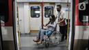 Petugas Light Rail Transit (LRT) Jakarta membantu mendorong kursi roda penumpang disabilitas dalam rangkaian gerbong kereta menggunakan kursi roda di Stasiun Pegangsaan Dua, Jakarta Utara, Selasa (24/1/2023). LRT Jakarta melakukan kampanye #NyamankanJakarta. (merdeka.com/Iqbal S. Nugroho)