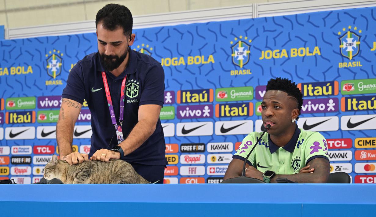 Kucing itu pun kemudian diusir oleh staf media Timnas Brasil dari meja konferensi mereka. (AFP/Nelson Almeida)