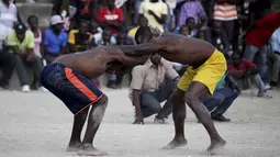 Dua pegulat sedang beraksi pada ajang gulat yang disebut Pinge wrestling competition di Port-au-Prince, Haiti, Sabtu (26/3/2016). Acara ini untuk memperingati Paskah di Haiti. (REUTERS/Andres Martinez Casares)