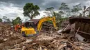 Alat berat dikerahkan untuk membuka tumpukan material, sementara anjing pelacak Unit K9 digunakan untuk menelusuri lokasi yang diduga menjadi titik tertimbun korban. Tampak dalam foto, tim penyelamat dan alat berat mencari korban yang tertimbun di bawah puing-puing rumah yang hancur di lokasi longsor di Desa Situkung, Banjarnegara, Jawa Tengah, pada Rabu 19 November 2025. (DEVI RAHMAN/AFP)