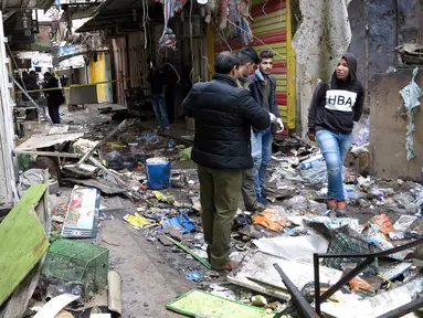 Petugas keamanan Irak memeriksa lokasi serangan bom yang terjadi di sebuah pasar di Baghdad, Irak (31/12). Pusat ledakan bom terjadi di dekat toko yang menjual suku cadang mobil di pasar al-Sinak. (Reuters/Ali al-Mashhadan )