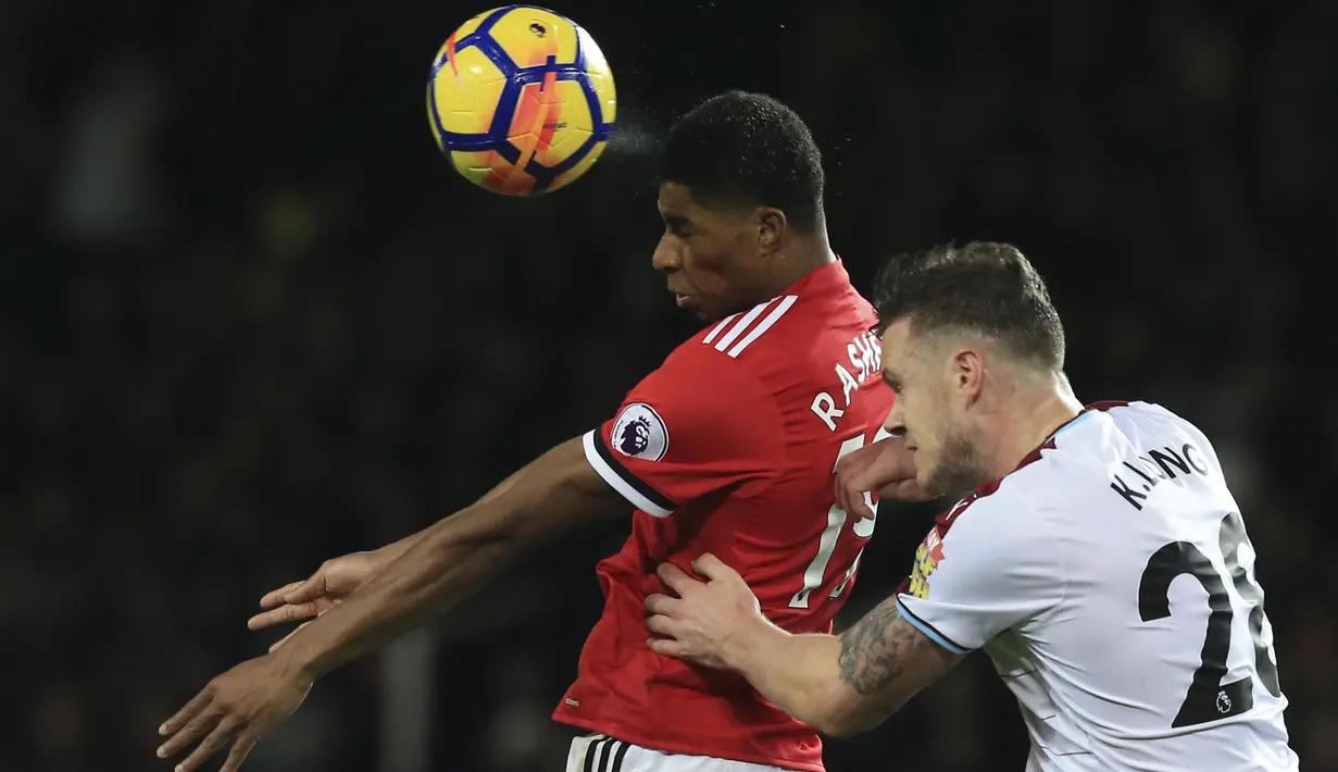 Pemain Manchester United, Marcus Rashford (kiri) berduel dengan pemain Burnley, Kevin Long (kanan) pada lanjutan Premier League di Old Trafford,  Manchester (26/12/2017).  MU bermain imbang 2-2. (AFP/Lindsey Parnaby)