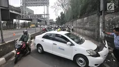 Pengendara sepeda motor tersendat saat melintasi lokasi kecelakaan taksi menabrak tiang di Jalan Ahmad Yani, Jakarta, Rabu (1/8). Kecelakaan terjadi setelah sopir taksi berusaha menghindari pengendara sepeda motor di depannya. (Merdeka.com/Iqbal Nugroho)