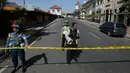Aparat kepolisian menutup jalan menuju Polrestabes Surabaya setelah serangan bom bunuh diri di Jawa Timur, Senin (14/5). Diduga, pelaku seorang pria dan wanita yang berboncengan dengan sepeda motor dan membawa seorang anak kecil (AP/Achmad Ibrahim)