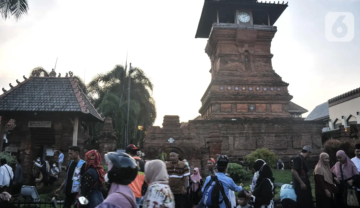 Peziarah bersantai di dekat Menara Kudus, Kauman, Kabupaten Kudus, Jawa Tengah, Rabu (30/3/2022). Menara berusia 473 tahun yang dahulu berfungsi sebagai tempat mengumandangkan azan menjadi lokasi favorit pengunjung untuk bersantai usai berziarah di Makam Sunan Kudus. (merdeka.com/Iqbal S. Nugroho)