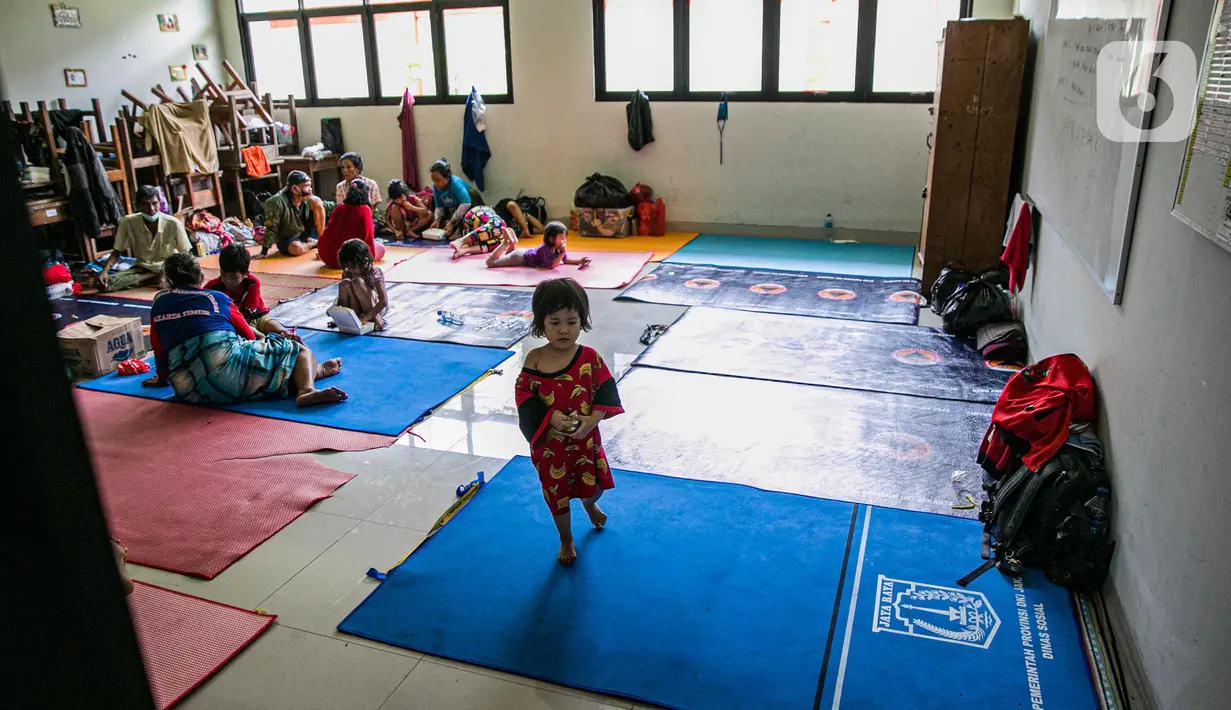 Seorang balita korban banjir terlihat di salah ruang kelas di gedung SDN 01/02 Kampung Melayu, Jakarta, Selasa (9/2/2021). Gedung sekolah di Kebon Pala tersebut menjadi salah satu posko pengungsian bagi sebagian korban banjir Kampung Melayu. (Liputan6.com/Faizal Fanani)