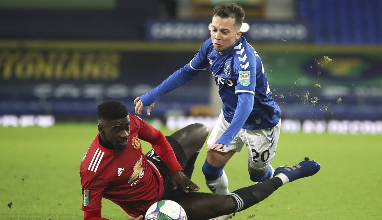 Striker Everton, Bernard (kanan), dijatuhkan bek Manchester United, Axel Tuanzebe, dalam laga perempatfinal Piala Liga Inggris Carabao Cup di Goodison park, Rabu (23/12/2020). Everton kalah 0-2 dari Manchester United. (AP/Nick Potts/Pool)