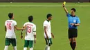 Wasit Kim Heegon dari Korea memberikan kartu kuning kepada pemain Indonesia U-23, M. Abduh Lestaluhu (3) setelah melakukan pelanggaran terhadap pemain Myanmar U-23. (Bola.com/Arief Bagus)