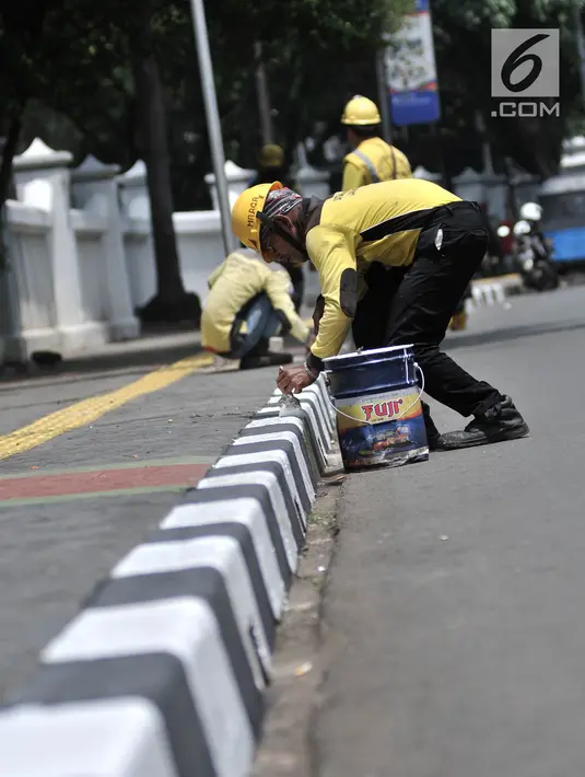 Petugas Suku Dinas Bina Marga Jakarta Timur saat menyelesaikan pengecatan trotoar di Jalan Persahabatan Raya, Jakarta, Rabu (27/3). Kegiatan pengecatan ini rutin dilakukan guna merawat sekaligus mempercantik jalur pedestrian tersebut. (merdeka.com/Iqbal S. Nugroho)
