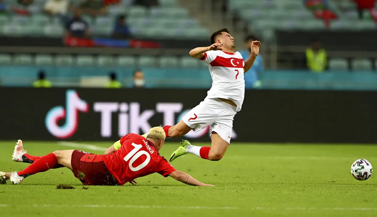 Pemain Swiss Granit Xhaka (kiri) berebut bola dengan pemain Turki Cengiz Under pada pertandingan Grup A Euro 2020 di Stadion Olimpiade Baku, Baku, Azerbaijan, Minggu (20/6/2021). Swiss menang 3-1. (Ozan Kose/Pool via AP)