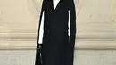 Aktris Isabelle Adjani mengenakan jubah sutra dan wol hitam Dior, kemeja katun putih, dan legging bermotif houndstooth Cruise 2022. Dia juga mengenakan tas Dior Hobo, sarung tangan, kacamata hitam dan sepatu. (Dior)