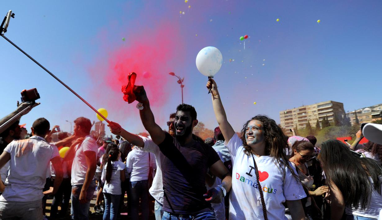 Peserta bersuka cita saat mengikuti acara marathon bertajuk 'I Love Damaskus' di Umayyah Square Damaskus, Suriah, Jumat (7/10). (REUTERS / Omar Sanadiki)
