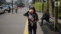 Seorang wanita menutupi wajahnya selama gelombang panas di Jakarta, Selasa (22/10/2019).  BMKG memprediksi wilayah Indonesia akan mengalami panas selama kurang lebih satu minggu ini. Hal ini dikarenakan matahari yang berada dekat dengan jalur khatulistiwa. (Liputan6.com/Faizal Fanani)