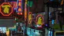 Sebuah bus melewati tanda-tanda neon 'Broadway Ballrooms' di Hong Kong (16/4). Wu Chi-kai merupakan salah satu pengrajin neon sign yang tersisa dari jenisnya di Hong Kong. (AFP Photo/Philip Fong)