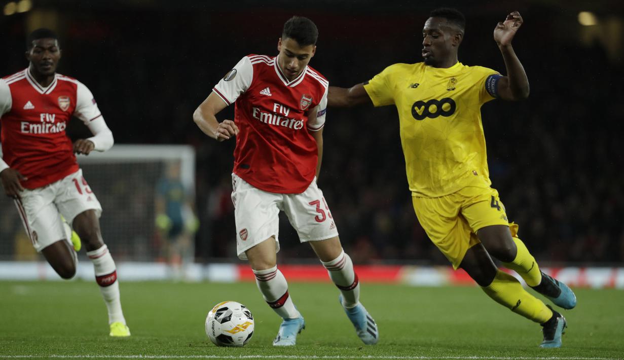 Penyerang Arsenal, Gabriel Martinelli (tengah) mengontrol bola dari kawalan Standard Liege, Dimitri Lavalee,  kanan) pada lanjutan pertandingan grup F Liga Europa di Stadion Emirates, London (3/10/2019). Arsenal menang telak 4-0 atas Standard Liege. (AP Photo/Matt Dunham)