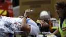 Petugas membawa penumpang bus yang tertabrak jembatan untuk dirawat di Australia (22/2). Bus wisata yang membawa 19 penumpang tersebut menabrak pembatas kolong jembatan yang memiliki tinggi 10 kaki (3 meter). (REUTERS/Mal Fairclough)