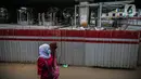 Pejalan kaki melintas di dekat area proyek penataan Stasiun Tebet, Jakarta, Senin (28/12/2020). Pemerintah Provinsi DKI Jakarta melakukan penataan kawasan Stasiun Tebet untuk mengoptimalkan integrasi antarmoda bagi penumpang yang mengakses transportasi kereta api. (Liputan6.com/Faizal Fanani)