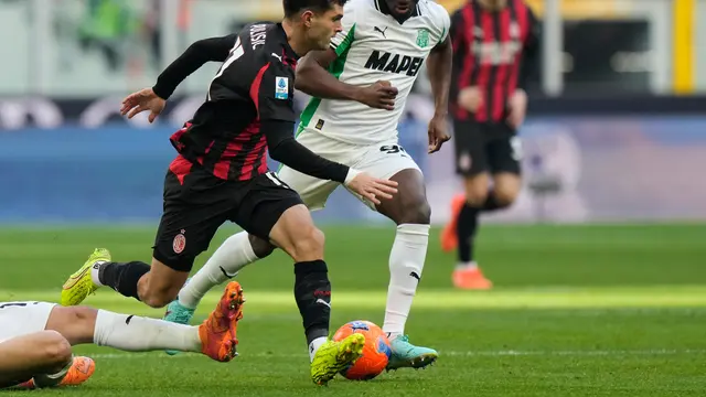 Christian Pulisic (kiri) dipepet Ismael Kone di laga AC Milan vs Sassuolo di pekan ke-15 Serie A 2025/2026 di San Siro, Minggu (14/12/2025). (AP Photo/Luca Bruno)