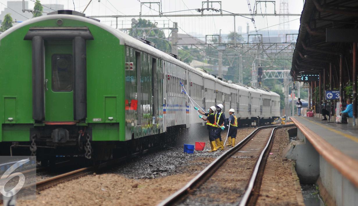Pekerja mencuci kereta di Stasiun Pasar Senen, Jakarta, Jumat (16/9). Uji coba penutupan perlintasan itu akan berlangsung selama satu bulan pada 1-31 Oktober 2016. (Liputan6.com/Gempur M Surya)