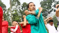 Presiden Jokowi melakukan gerakan tangan saat mengikuti senam pagi bersama di halaman Istana Bogor, Jawa Barat, Sabtu (12/8). (Liputan6.com/Angga Yuniar)