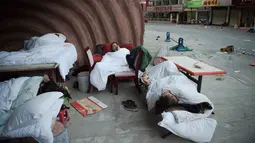 Sejumlah orang tidur di luar rumah mereka di Zhangzha, provinsi Sichuan, China barat daya, Kamis (10/8). Ratusan warga memilih menghabiskan malam di luar rumah setelah gempa 6,5 SR mengguncang wilayah itu dan menewaskan belasan orang (Nicolas ASFOURI/AFP)