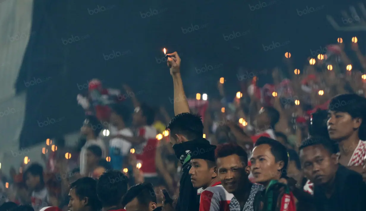 K-Conk Mania menyalakan lilin dan korek api tanda perayaan ulang tahun yang ke-7 saat mendukung timnya Madura United melawan Persiba Balikpapan pada Torabika SC 2016 di Stadion Gelora Bangkalan, Senin(13/6/2016).  (Bola.com/Nicklas Hanoatubun)