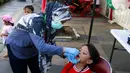 Seorang anak mendpaatkan vaksin polio tetes dari tenaga kesehatan dari Puskesmas Menteng saat hari bebas kendaraan bermotor atau car free day di kawasan Bundaran Hotel Indonesia (HI), Jakarta, Minggu (8/9/2024). (Liputan6.com/Herman Zakharia)