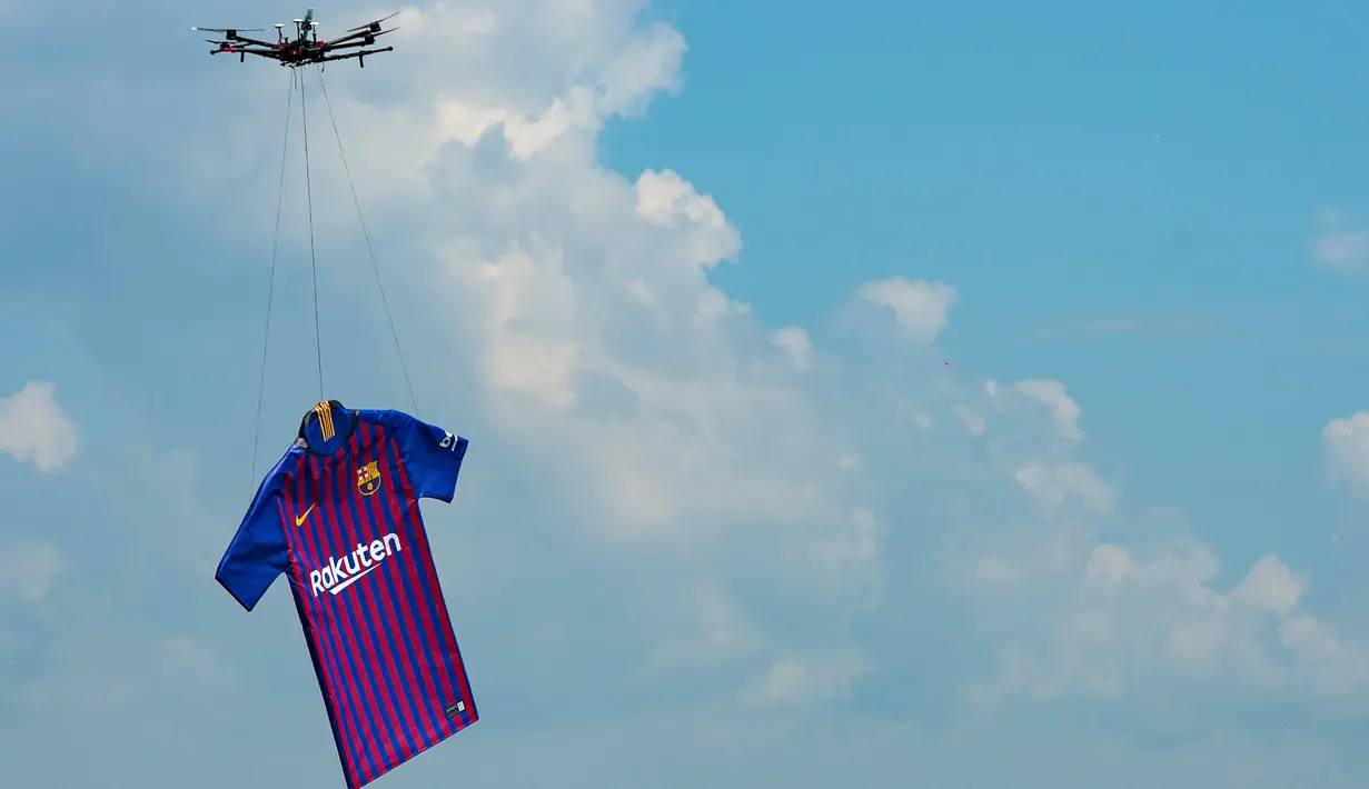 Barcelona menggunakan drone menerbangkan jersey terbarunya untuk musim 2018/2019 saat diperkenalkan di Montjuic Swimming Pool, 19 Mei 2018. Dilansir dari situs resminya, seragam kali ini menunjukkan penghormatan kepada kota Barcelona. (AFP/Josep LAGO)