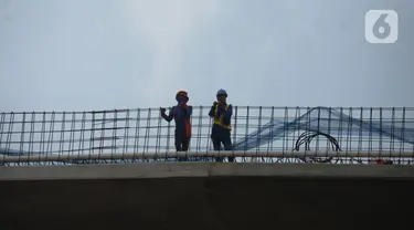 Pekerja menyelesaikan proyek pembangunan jalan layang (flyover) Cakung, Jakarta, Kamis (28/1/2021). Bina Marga DKI Jakarta akan melakukan uji coba penggunaan flyover dengan biaya pembangunan  Rp 261 miliar tersebut pada Febuari mendatang. (merdeka.com/Imam Buhori)