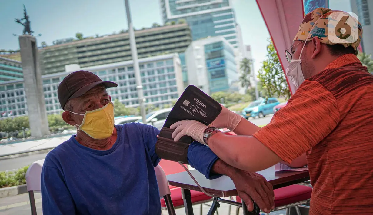 Petugas medis mengecek kesehatan warga sebelum vaksin di Gerai Vaksinasi Presisi, Bundaran HI, Menteng, Jakarta, Minggu (20/3/2022). Kegiatan vaksin booster diinisasi Polsek Menteng bersama tiga pilar menggunakan jenis vaksin Astra Zeneca dengan kuota 100 dosis per hari. (Liputan6.com/Faizal Fanani)