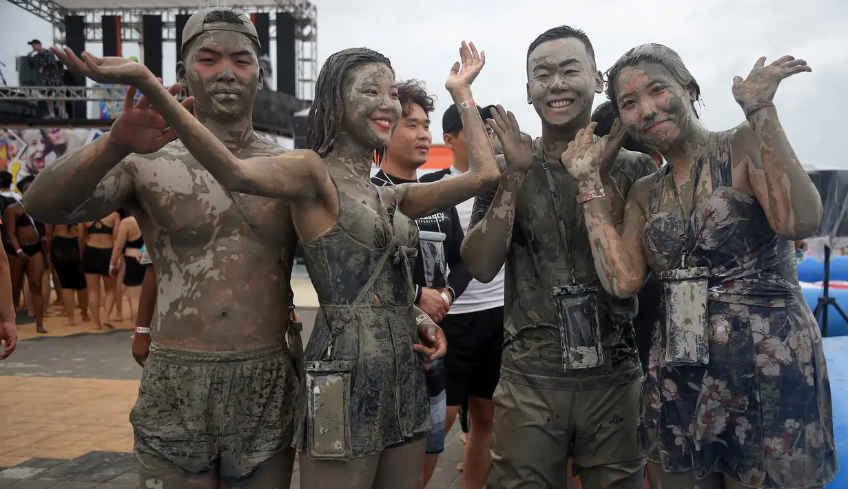 Wisatawan bermain di kolam lumpur selama Boryeong Mud Festival atau Festival Lumpur Boryeong di pantai Daecheon, Korea Selatan, Sabtu (20/7/2019).  Ajang mandi lumpur sepuasnya di Korea Selatan ini, merupakan festival khusus untuk memeriahkan musim panas di negeri ginseng. (Minji SUH/AFP)