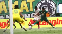 Pemain Bali United, Privat Mbarga (kiri), mencoba lepas dari penjagaan pemain Persebaya, Andre Tata, dalam pertandingan BRI Liga 1 2023/2024 di Stadion Gelora Bung Tomo, Surabaya, Rabu (24/4/2024) sore WIB. (Bola.com/Aditya Wany)