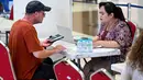 Gede Eka Sandi Asmadi menambahkan, berdasar data dari maskapai penerbangan, calon penumpang dari penerbangan yang mengalami penyesuaian jadwal tersebut berjumlah 3.197 penumpang. Tampak dalam foto, seorang penumpang berbicara dengan staf bandara di tengah gangguan penerbangan akibat serangan Israel-Amerika Serikat terhadap Iran, di Bandara Internasional I Gusti Ngurah Rai, Bali, pada Senin 2 Maret 2026. (SONNY TUMBELAKA/AFP)