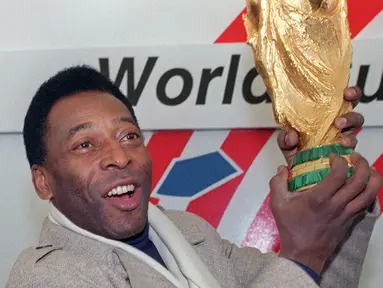 Mantan pemain sepak bola asal Basil, Edson Arantes do Nascimento atau Pele mengangkat trofi Piala Dunia di New York, Amerika Serikat, 7 Desember 1991. Pele, yang memiliki nama asli Edson Arantes do Nascimento, mulai bermain untuk Santos pada usia 15 tahun dan Timnas Brasil setahun kemudian, meledak di kancah sepak bola dunia saat berusia 17 tahun di Piala Dunia 1958. (HELAYNE SEIDMAN/AFP)