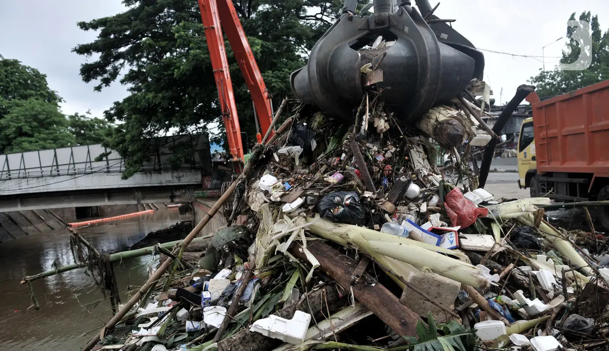 Sampah yang menumpuk di Pintu Air Manggarai dianggkut menggunakan alat berat, Jakarta, Minggu (29/12/2019). Volume sampah di Pintu Air Manggarai mencapai 84 meter kubik atau setara tujuh truk. (merdeka.com/Iqbal Nugroho)